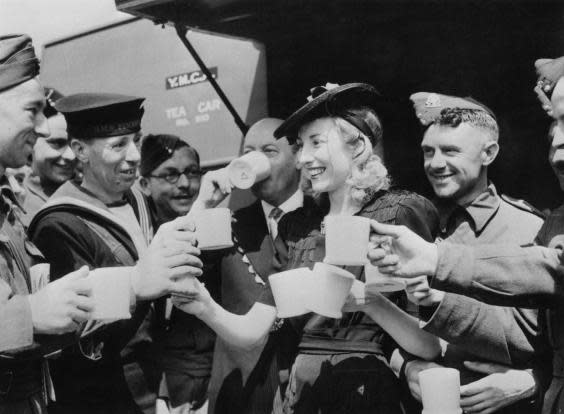 Dame Vera Lynn serves cups of tea to servicemen in 1942 (Getty)