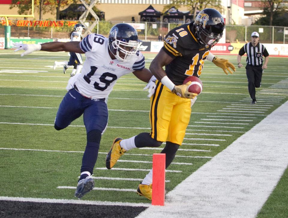 Hamilton Tiger-Cats' Dobson Collins (R) is pushed out of bounds just shy of the touchdown marker by Toronto Argonauts' Jalil Carter in the first half of their CFL football game in Guelph October 14, 2013. REUTERS/Fred Thornhill (CANADA - Tags: SPORT FOOTBALL)