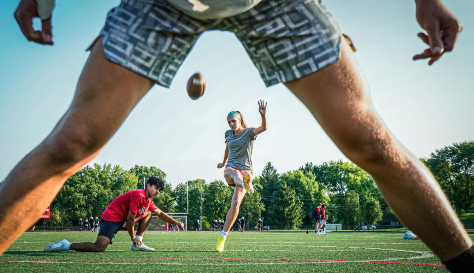 Paige Dill, a sophomore kicker for the Park Tudor Panthers varsity boys football team and a starting defender for the girls soccer team, practices her kicks with teammates Adam Verma holding the ball and Nolan Whitehead snapping the ball.