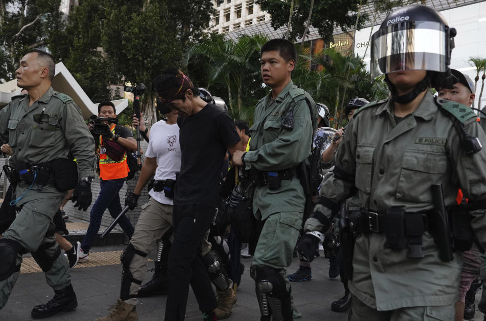 Hong Kong police detain a man on the streets of Hong Kong on Saturday, Oct. 5, 2019. All subway and train services were suspended, lines formed at the cash machines of shuttered banks, and shops were closed as Hong Kong dusted itself off and then started marching again Saturday after another night of rampaging violence decried as "a very dark day" by the territory's embattled leader. (AP Photo/Vincent Yu)