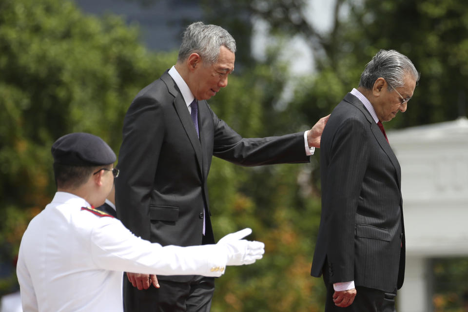 Malaysia's Prime Minister Mahathir Mohamad, right, inspects an honor guard with Singapore's Prime Minister Lee Hsien Loong during a visit at the Istana in Singapore, Monday, Nov. 12, 2018. (Feline Lim/Pool Photo via AP)