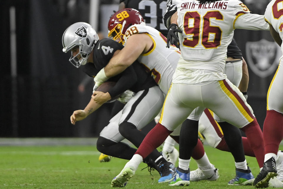 Washington Football Team defensive tackle Matthew Ioannidis (98) sacks Las Vegas Raiders quarterback Derek Carr (4) during the second half of an NFL football game, Sunday, Dec. 5, 2021, in Las Vegas. (AP Photo/David Becker)