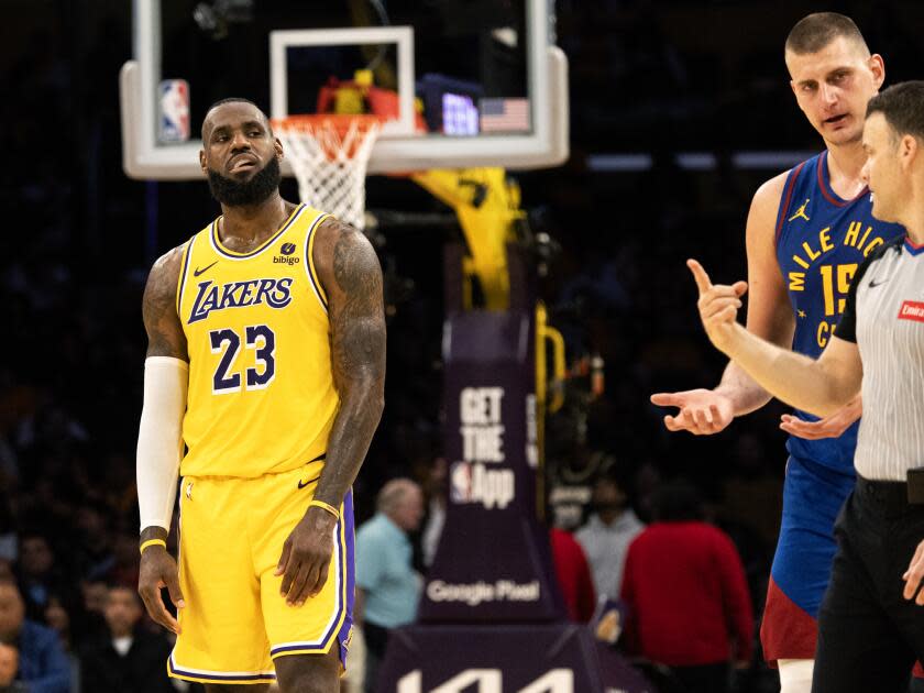 O atacante do Lakers, LeBron James, olha enquanto o pivô do Nuggets, Nikola Jokic, conversa com o árbitro 