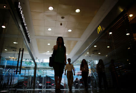 FILE PHOTO: A woman walks next to a McDonald's restaurant and a Starbucks coffee store at a shopping mall in Shanghai, China July 28, 2014. REUTERS/Carlos Barria/File Photo