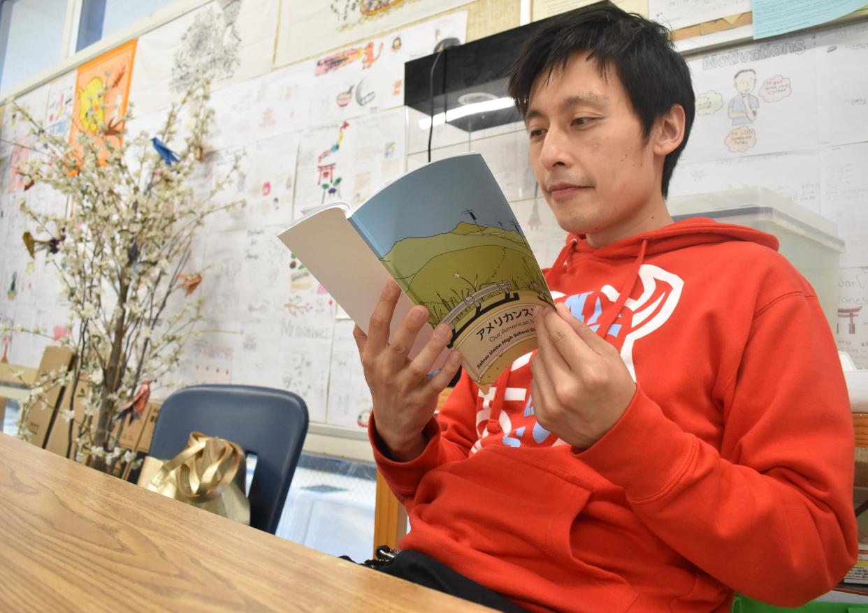 North Salinas High School Japanese teacher Cameron Chien reads 'Our American Stories Volume 2,' a book composed partly by his students.