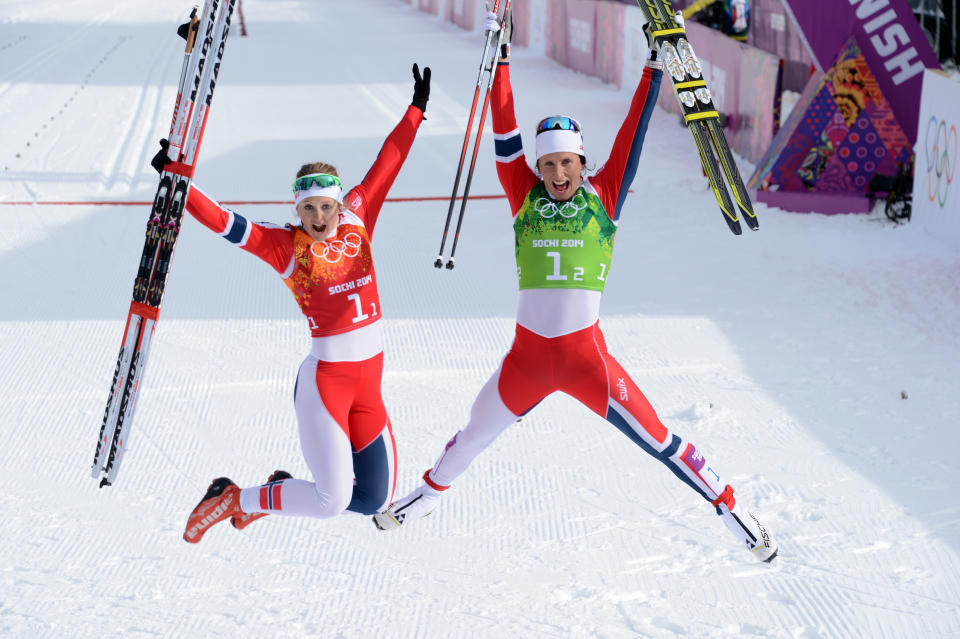 (LtoR) Norway's Ingvild Flugstad Oestberg and Norway's Marit Bjoergen celebrate after the Women's Cross-Country Skiing Team Sprint Classic Final at the Laura Cross-Country Ski and Biathlon Center during the Sochi Winter Olympics on February 19, 2014 in Rosa Khutor near Sochi.  AFP PHOTO / KIRILL KUDRYAVTSEV        (Photo credit should read KIRILL KUDRYAVTSEV/AFP/Getty Images)