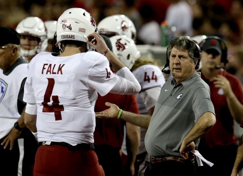 Washington State head coach Mike Leach, right, talks to quarterback Luke Falk in the first half during an NCAA college football game against Arizona, Saturday, Oct. 28, 2017, in Tucson, Ariz. (AP Photo/Rick Scuteri)