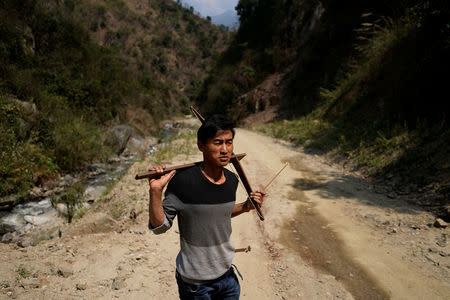 Zhang, a 26-year old ethnic Lisu man carries his crossbow at his village of Luzhang township of Nujiang Lisu Autonomous Prefecture in Yunnan province, China, March 26, 2018. REUTERS/Aly Song