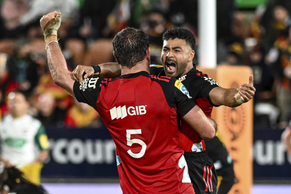 Richie Mo'unga, right, and teammate Sam Whitelock of the Crusaders celebrate after defeating the Chiefs in the Super Rugby Pacific final between the Chiefs and the Crusaders in Hamilton, New Zealand, Saturday, June 24, 2023. (Andrew Cornaga/Photosport via AP)
