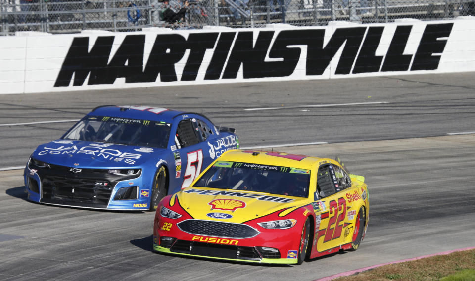 Driver Joey Logano (22) passes Jeb Burton (51) during the Monster Energy NASCAR Cup Series auto race at Martinsville Speedway in Martinsville, Va., Sunday, Oct. 28, 2018. (AP Photo/Steve Helber)