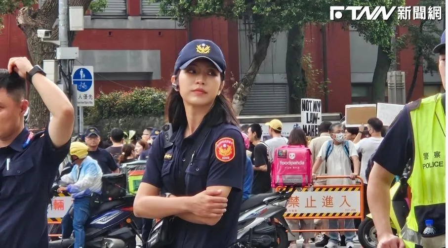 立法院擠滿抗議人潮，一名正妹女警雙手抱胸，讓人眼睛為之一亮。（圖／翻攝畫面 ）