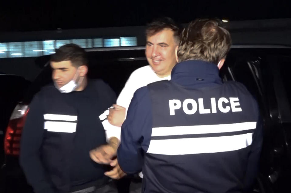 In this handout photo taken from video released by Georgian Interior Ministry Press Service, Georgian Police officers escort former President Mikheil Saakashvili after he was arrested in Rustavi, Georgia, Friday, Oct. 1, 2021. The prime minister of Georgia says former President Mikheil Saakashvili has been arrested. The announcement Friday by Prime Minister Irakli Garibashvili came about 18 hours after Saakashvili, who was convicted in absentia and has lived in Ukraine in recent years, posted on Facebook that he had returned to the country. (Georgian Interior Ministry Press Service via AP)