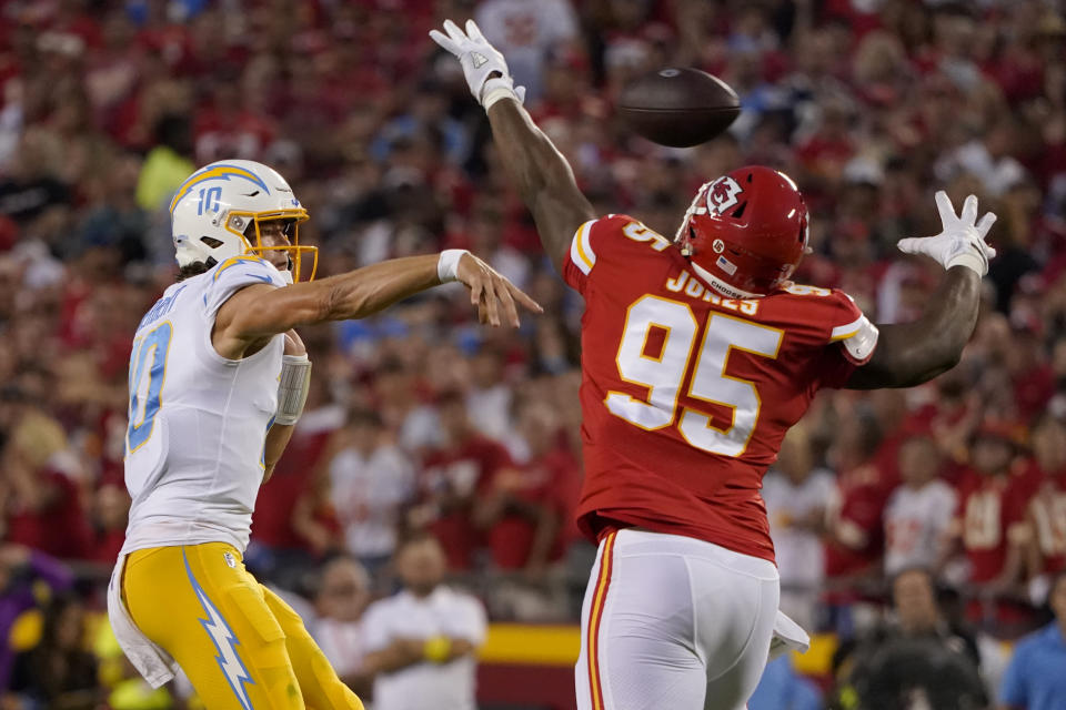 Los Angeles Chargers quarterback Justin Herbert, left, throws as Kansas City Chiefs defensive tackle Chris Jones (95) defends during the first half of an NFL football game Thursday, Sept. 15, 2022, in Kansas City, Mo. (AP Photo/Ed Zurga)