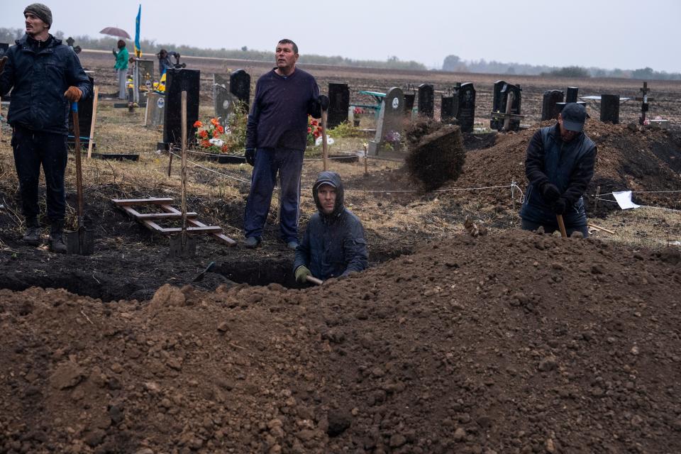 Men dig graves for victims of a rocket strike at a graveyard in the village of Hroza, Ukraine (Copyright 2023 The Associated Press. All rights reserved.)
