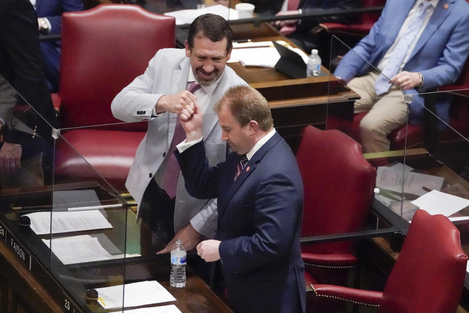 Rep. William Lamberth, R-Portland, bottom, bumps fists with Rep. Jeremy Faison, R-Cosby, after Lamberth's bill allowing most adults to carry handguns without obtaining a permit passed, Monday, March 29, 2021, in Nashville, Tenn. (AP Photo/Mark Humphrey)