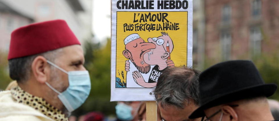 Un dessin de « Charlie Hebdo » est brandi lors de la manifestation en hommage à Samuel Paty, le 18 octobre 2020, place de la République à Paris.
