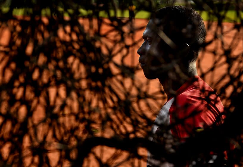 Dennis Kasumba takes a break during batting practice at the National field in Guyaza, Uganda.