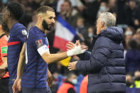 France's head coach Didier Deschamps, right, and France's Karim Benzema shake hands during the World Cup 2022 group D qualifying soccer match between France and Kazakhstan at the Parc des Princes stadium in Paris, France, Saturday, Nov. 13, 2021. (AP Photo/Michel Euler)