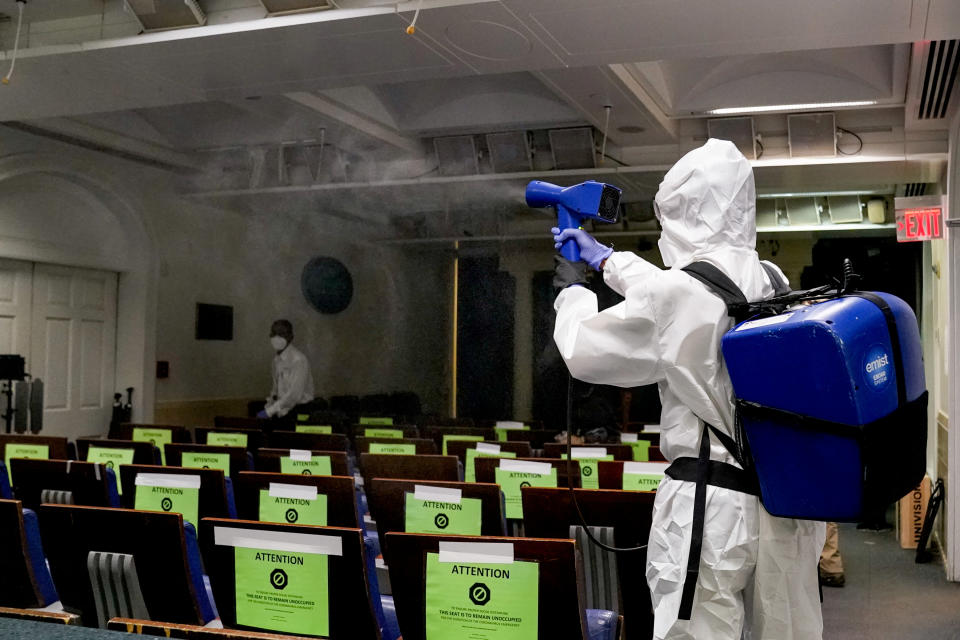 A member of the White House cleaning staff sprays the press briefing room the evening of U.S. President Donald Trump's return from Walter Reed Medical Center after contracting the coronavirus disease (COVID-19), in Washington, U.S., October 5, 2020. (Erin Scott/Reuters)