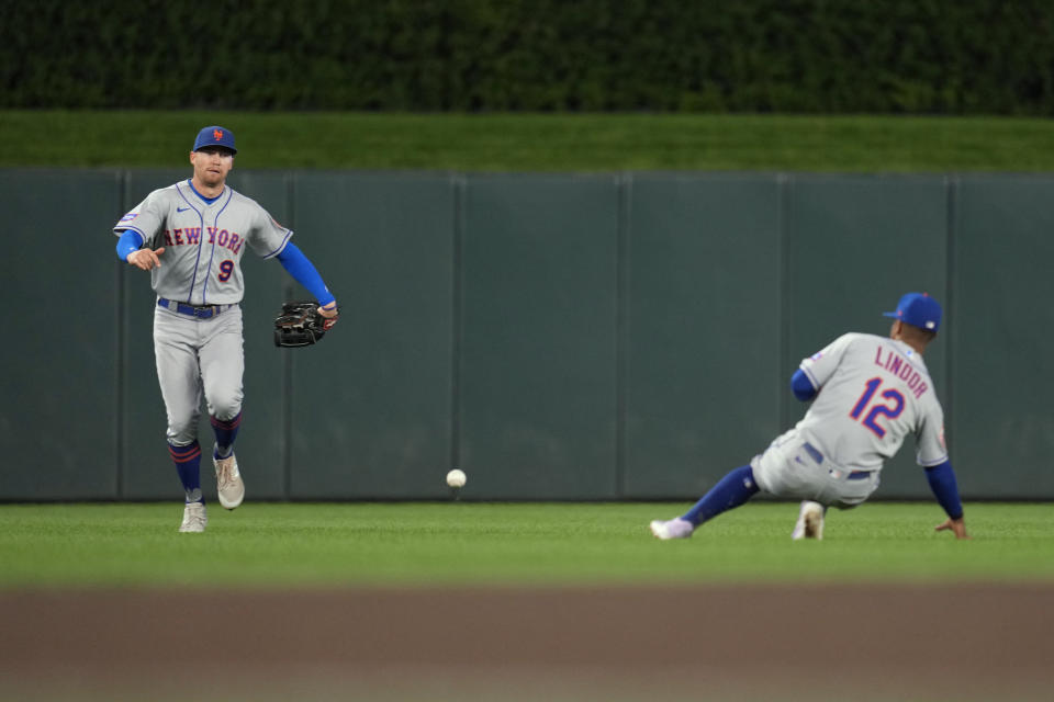 New York Mets center fielder Brandon Nimmo, left, runs to field an RBI single by Minnesota Twins' Max Kepler, while shortstop Francisco Lindor watches during the seventh inning of a baseball game Friday, Sept. 8, 2023, in Minneapolis. (AP Photo/Abbie Parr)