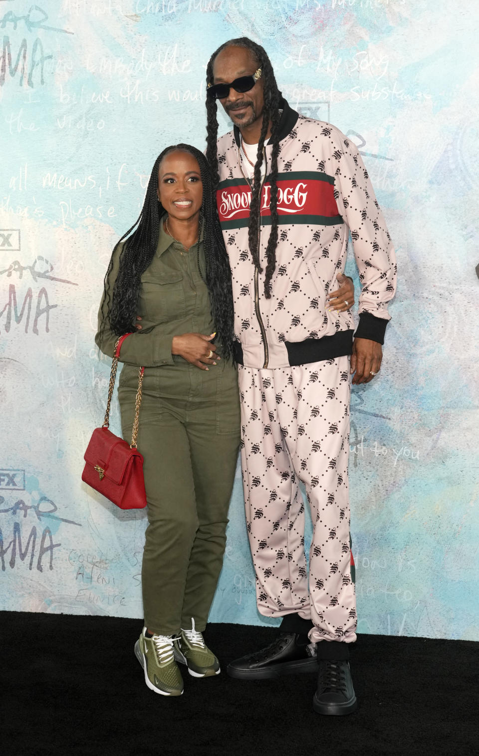 Rapper Snoop Dogg, right, and his wife Shante Broadus pose together at the premiere of the FX docuseries, Tuesday, April 18, 2023, at The Ted Mann Theater in Los Angeles. The series explores the legacies of rapper Tupac Shakur and his mother Afeni. (AP Photo/Chris Pizzello)