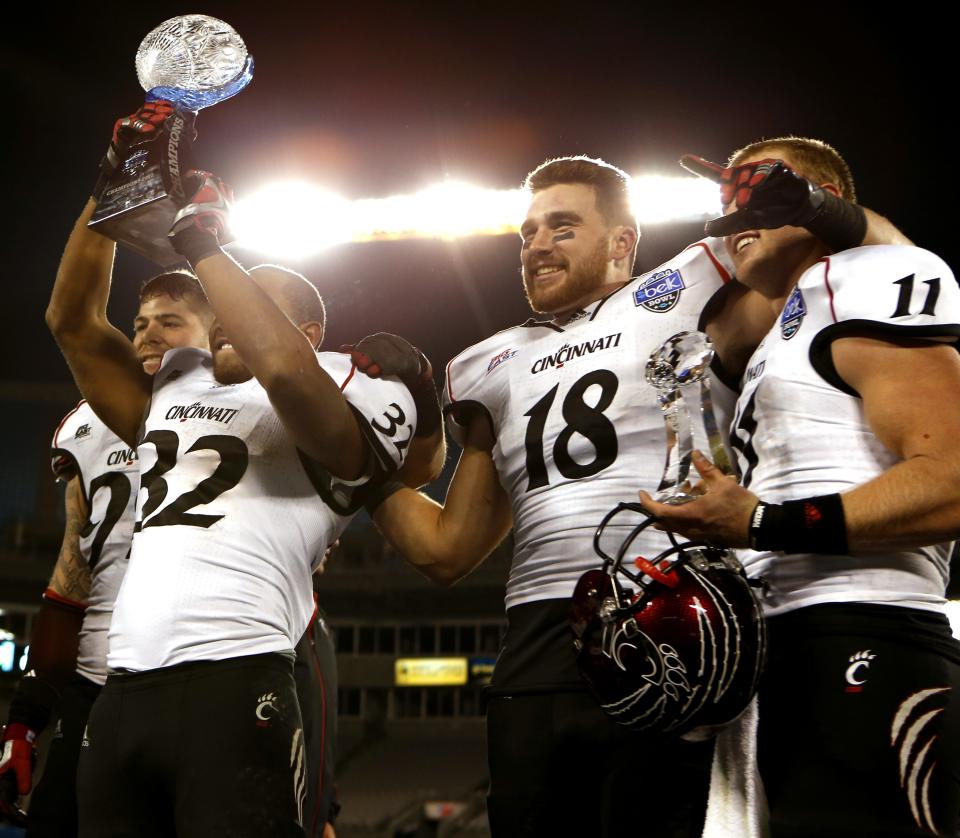 Cincinnati Bearcats DE Dan Giordano (99), left, running back George Winn (32), TE Travis Kelce (18) and quarterback Brendon Kay (11) celebrate on stage after UC beat Duke 48-43 in the Belk Bowl Dec. 27, 2012. Kelce had the go-ahead touchdown in the game. He was a third-round pick the following spring in the 2013 NFL Draft.