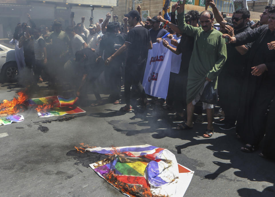 Supporters of Shiite Muslim leader Moqtada Sadr burn a rainbow flag, in response to the burning of a copy of the Quran in Sweden, during open-air Friday prayers in Basra, Iraq, Friday, June 30, 2023. (AP Photo/ Nabil al-Jurani)