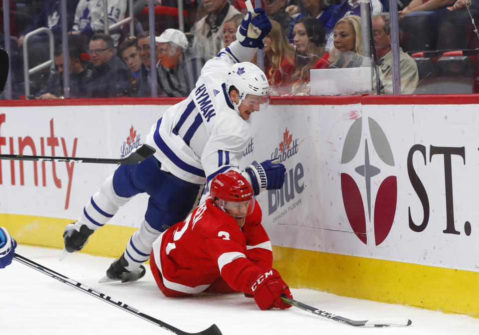 Toronto Maple Leafs center Zach Hyman (11) and Detroit Red Wings defenseman Nick Jensen (3) battle for the puck during the first period of an NHL hockey game Thursday, Oct. 11, 2018, in Detroit. (AP Photo/Paul Sancya)