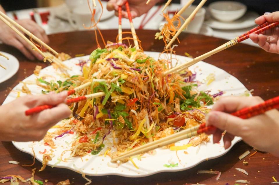 Boisterous wishes accompany the tossing of 'yee sang'.