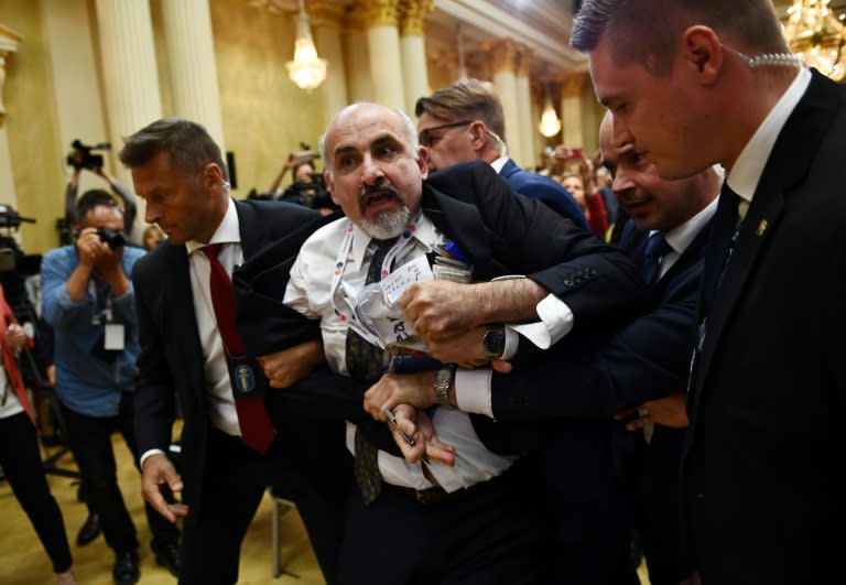 A man displaying a placard reading "nuclear weapons ban treaty" was escorted out of the room ahead of a joint press conference by the US and Russian presidents at the Presidential Palace in Helsinki