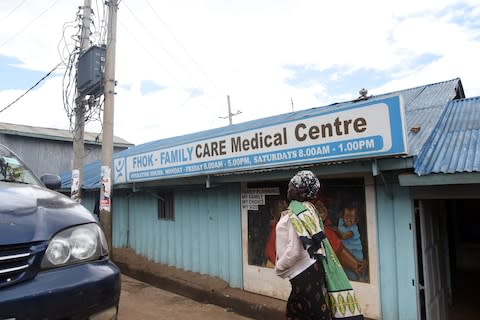 A Woman walking past Family Care Medical Centre in Kibera - Credit: Evans Habil/The Daily Nation