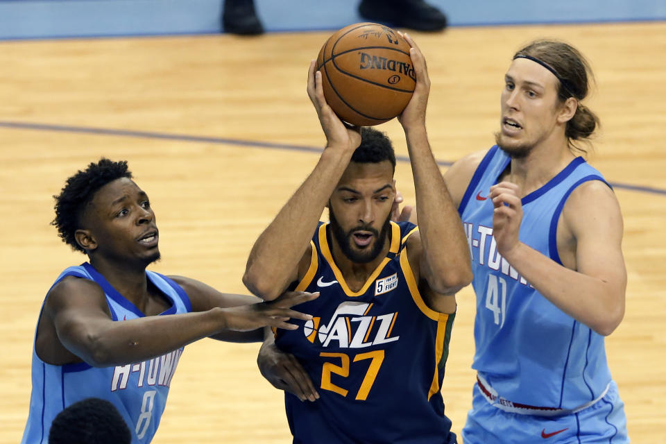 Utah Jazz center Rudy Gobert (27) looks to pass the ball under pressure from Houston Rockets forwards Jae'Sean Tate (8) and Kelly Olynyk (41) during the second half of an NBA basketball game Wednesday, April 21, 2021, in Houston. (AP Photo/Michael Wyke, Pool)