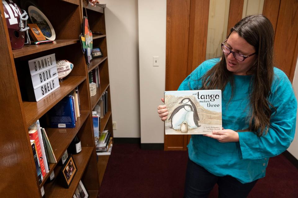 Rep. Erin Zwiener shows off the book “And Tango Makes Three.” “It’s two male penguins who raise a chick together from an egg,” she says of the children's book. “And it’s a true story.”