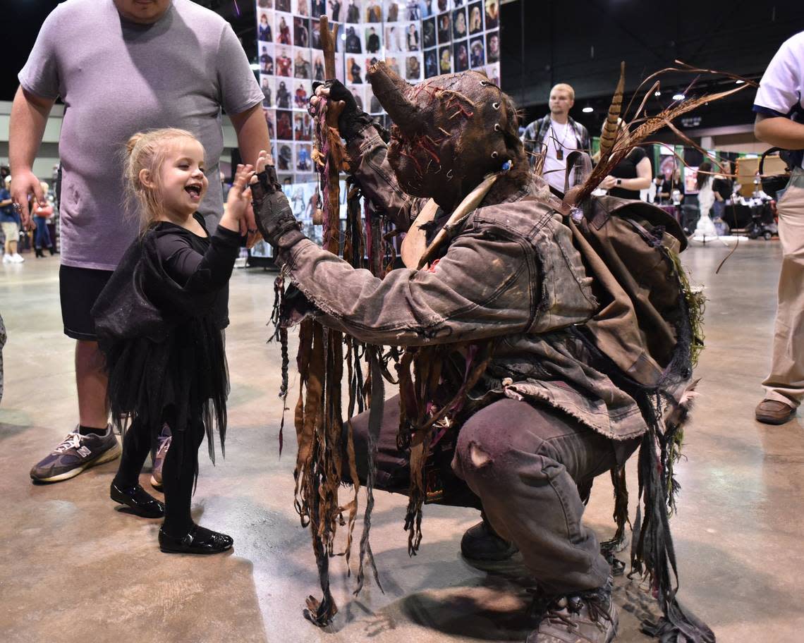 Ember Stull, 4, of Richmond slaps a High-5 with Jerry Dewayne Lester, dressed as a character called Hockomock, at ScareFest 2017.