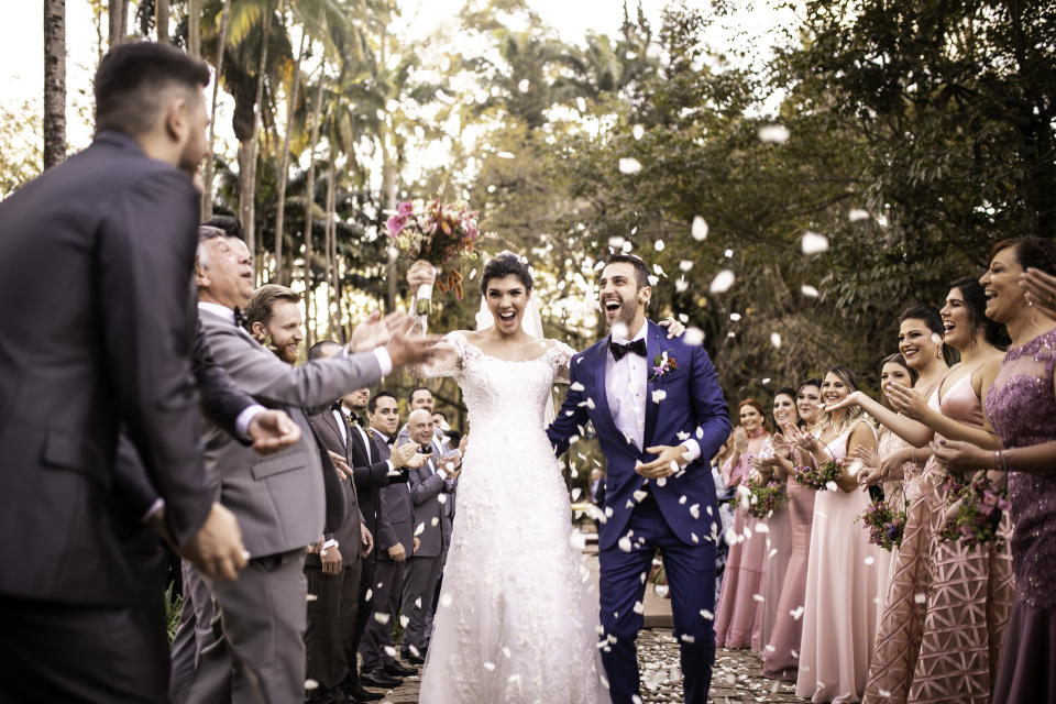 People throw confetti on a newlywed couple at a wedding.