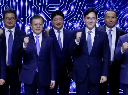 South Korean President Moon Jae-in and Samsung Electronics Vice Chairman, Jay Y. Lee pose for a group photo after a signing ceremony at Samsung Display's factory in Asan