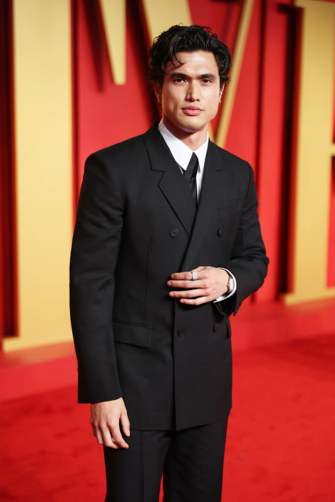 Man in a classic black suit and tie standing on the red carpet