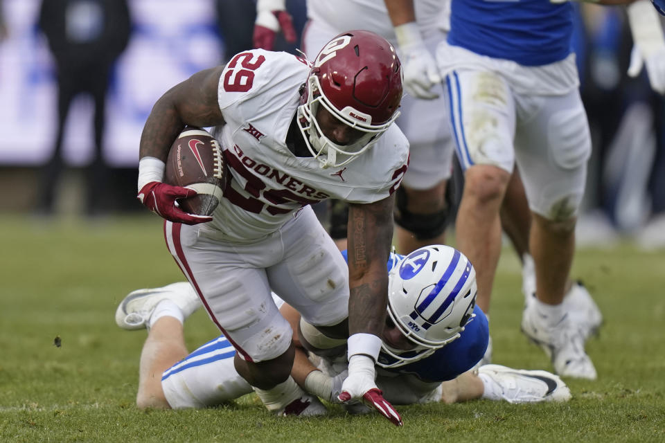 BYU safety Talan Alfrey, rear, tackles Oklahoma running back Tawee Walker (29) during the first half of an NCAA college football game Saturday, Nov. 18, 2023, in Provo, Utah. (AP Photo/Rick Bowmer)