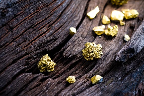 Pieces of gold ore on an old wooden rail.