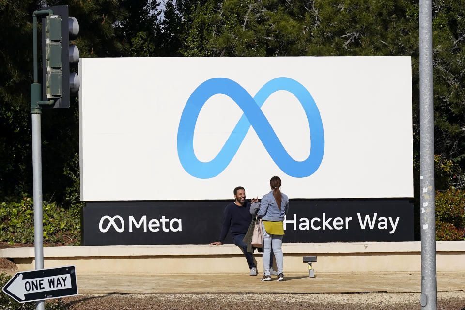 FILE - People talk near a Meta sign outside of the company's headquarters in Menlo Park, Calif., March 7, 2023. Meta's Oversight Board said Monday, Feb. 5, 2024, that it is urging the company to clarify its approach to manipulated media so its platforms can better beat back the expected flood of online election disinformation this year. The recommendations come after the board reviewed an altered video of President Joe Biden that was misleading but didn't violate the company's policies. (AP Photo/Jeff Chiu)