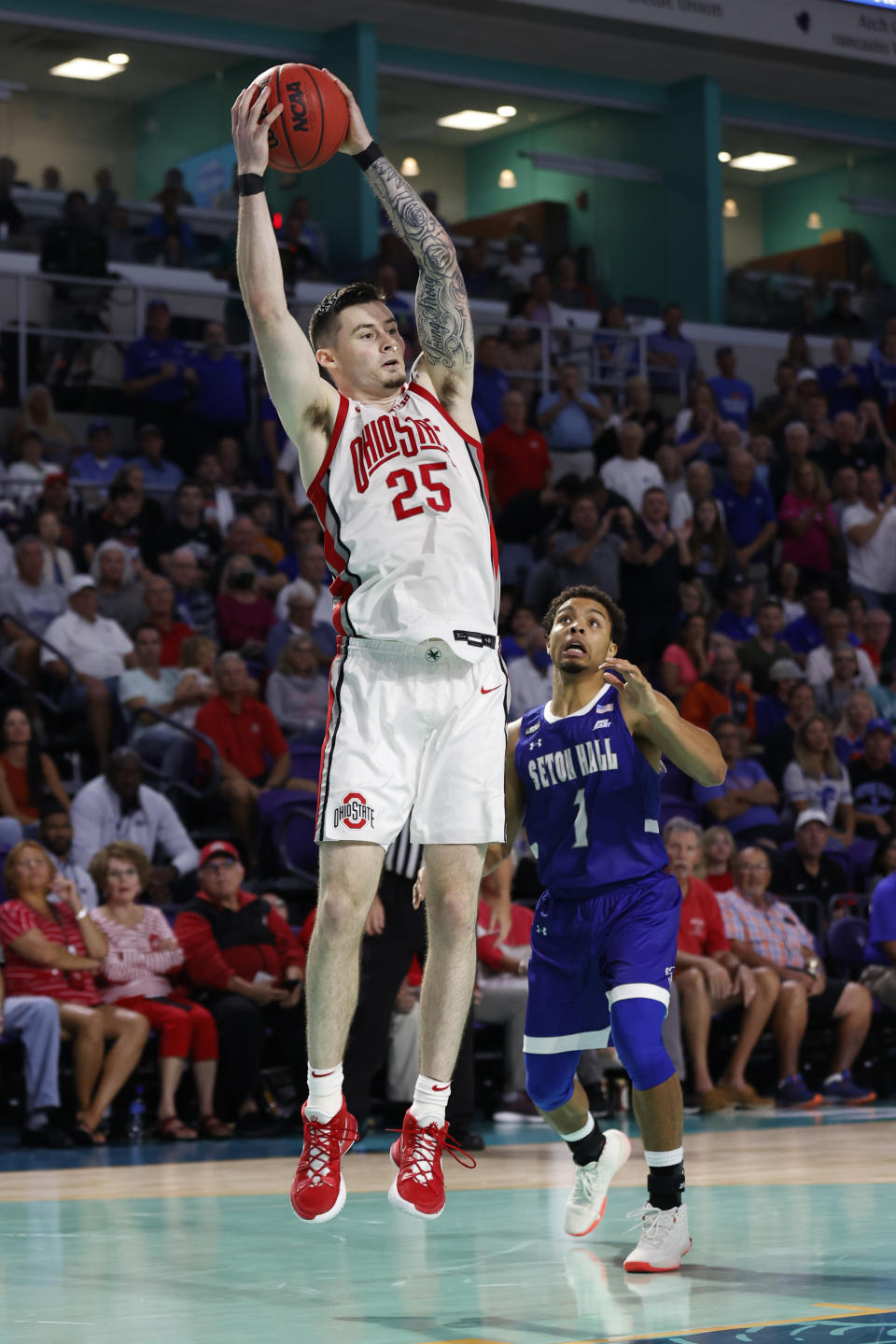 Ohio State forward Kyle Young (25) reaches for a pass in front of Seton Hall guard Bryce Aiken (1) during the second half of an NCAA college basketball game Monday, Nov. 22, 2021, in Fort Myers, Fla. (AP Photo/Scott Audette)