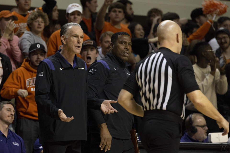 TCU head coach Jamie Dixon, front left, and associate head coach Tony Benford, front center, react to the referee, front right, in the second half of an NCAA college basketball game against Oklahoma State in Stillwater, Okla., Saturday, Feb. 4, 2023. (AP Photo/Mitch Alcala)