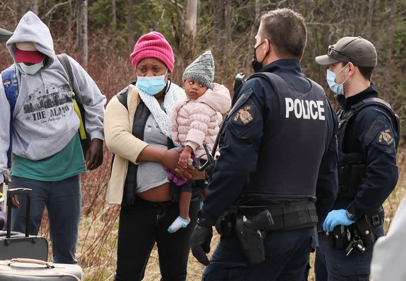 Asylum seekers cross into Canada near a checkpoint on Roxham Road