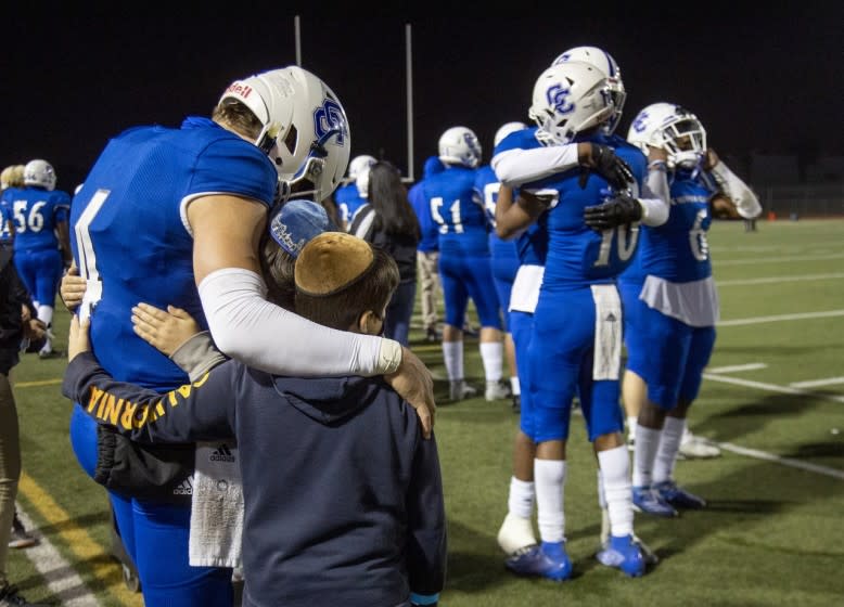 Culver City quarterback Zevi Eckhaus consoles his brothers Yanki and Chaim after his final high school game.