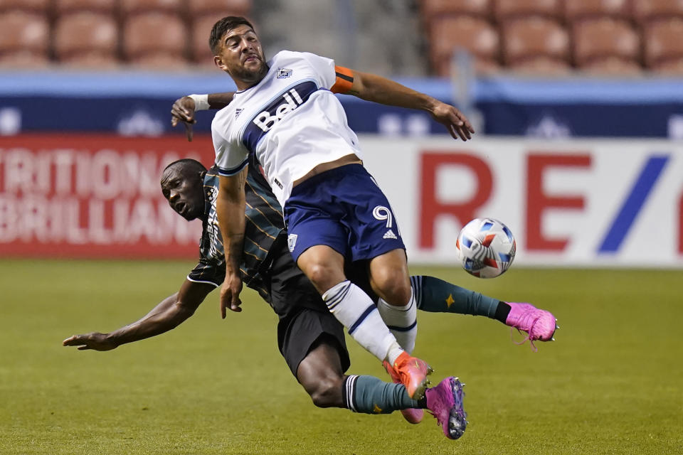 Los Angeles Galaxy S. Coulibaly, rear, and Vancouver Whitecaps forward Lucas Cavallini (9) battle for the ball in the first half during an MLS soccer match Wednesday, June 23, 2021, in Sandy, Utah. (AP Photo/Rick Bowmer)