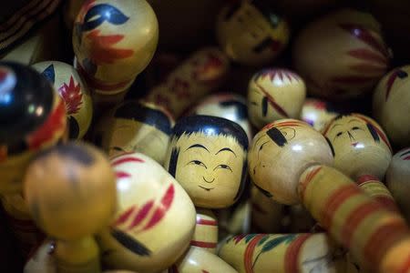 Traditional Kokeshi dolls from Japan's northern Tohoku area are piled up in a box at Boroichi flea market in Tokyo December 15, 2014. REUTERS/Thomas Peter