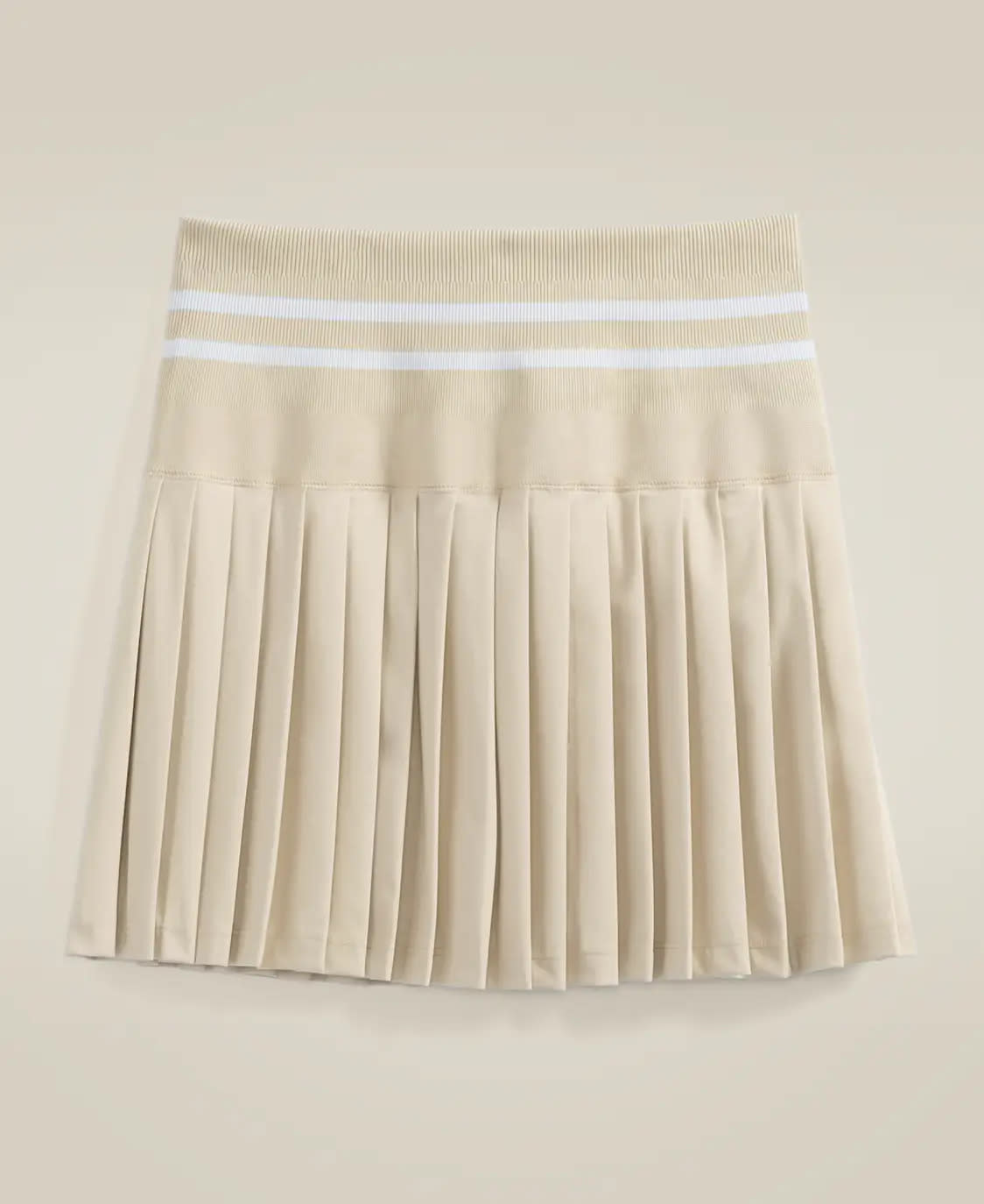 Plated tan tennis skirt with two white lines at wasit.