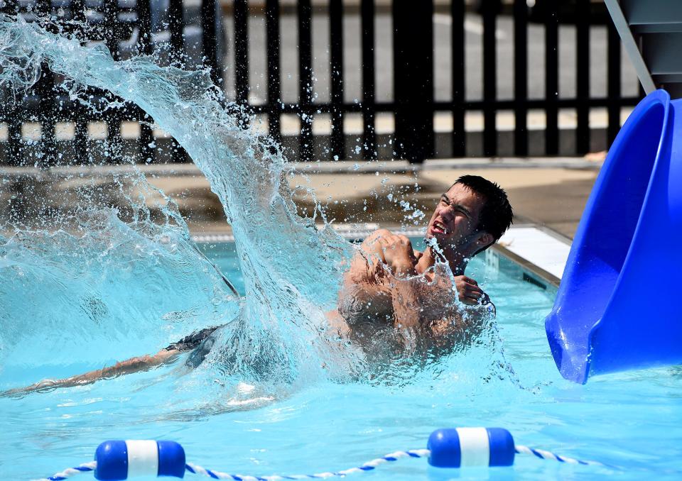 The city pool at Crompton Park opened Friday as Noah Martorana, 18, crashes into the water from the slide.