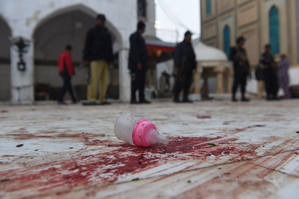 <p>Pakistani security personnel stand guard at the 13th century Muslim Sufi shrine of Lal. A baby feeder lies on the blood-stained floor at the 13th century Muslim Sufi shrine of Lal Shahbaz Qalandar a day after a bomb attack in the town of Sehwan in Sindh province, some 200 kilometres northeast of the provincial capital Karachi, on February 17, 2017. (Photo: Asif Hassan/AFP/Getty Images) </p>