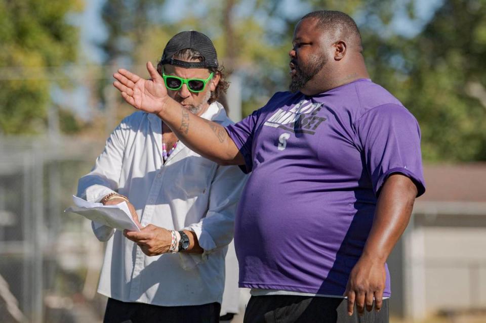 Sacramento High School football coaches Kimbbie Dayton, right, and Paul Peterson go over plays at practice on campus in July. Kevin Neri/kneri@sacbee.com